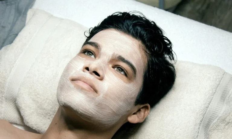 hombre con toalla en la cabeza realizando limpieza facial con vapor en casa.